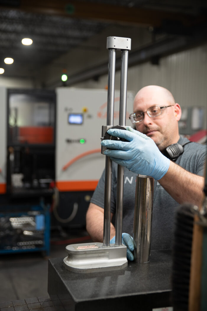 Travailleur heureux comme journalier dans un environnement propre et sécuritaire en train de confirmer la qualité de la pièce produite