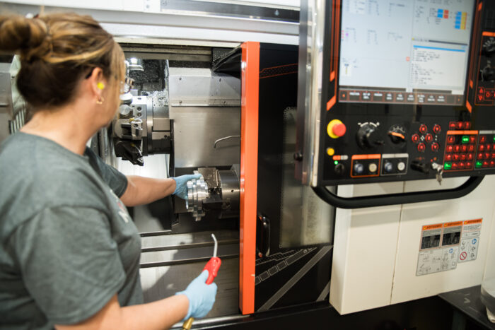 Opérateur CNC en train de faire la production de pièce de haute précision 
